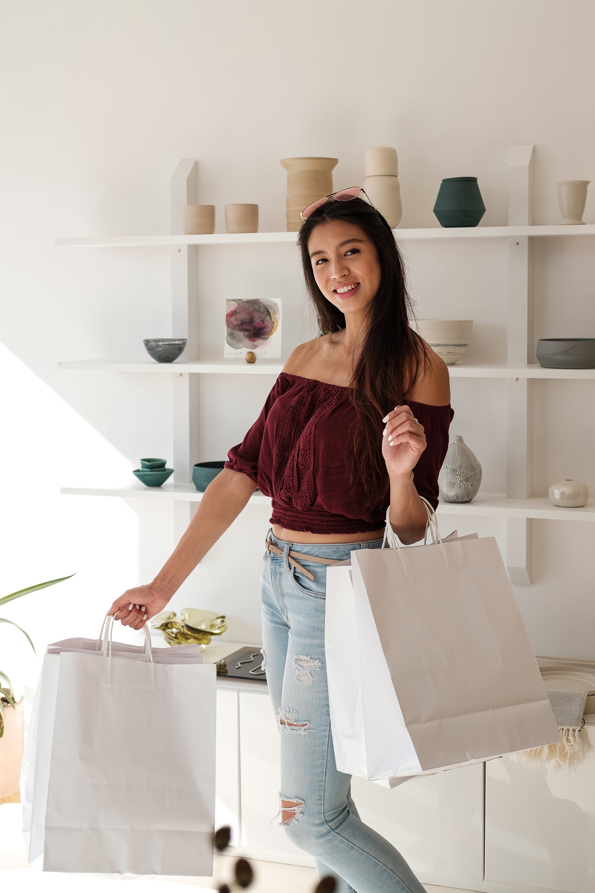 happy-customer-smiles-and-holds-white-shopping-bags - Home Kartz